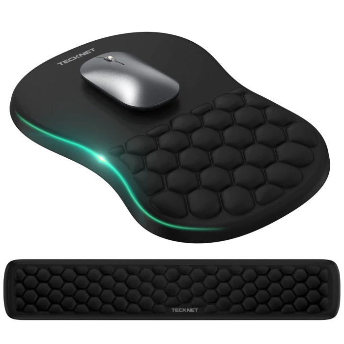 TECKNET ergonomic mouse pad and matching wrist rest set in black with a honeycomb texture, shown on a white background with a silver mouse placed on the pad and a glowing green LED light accent.